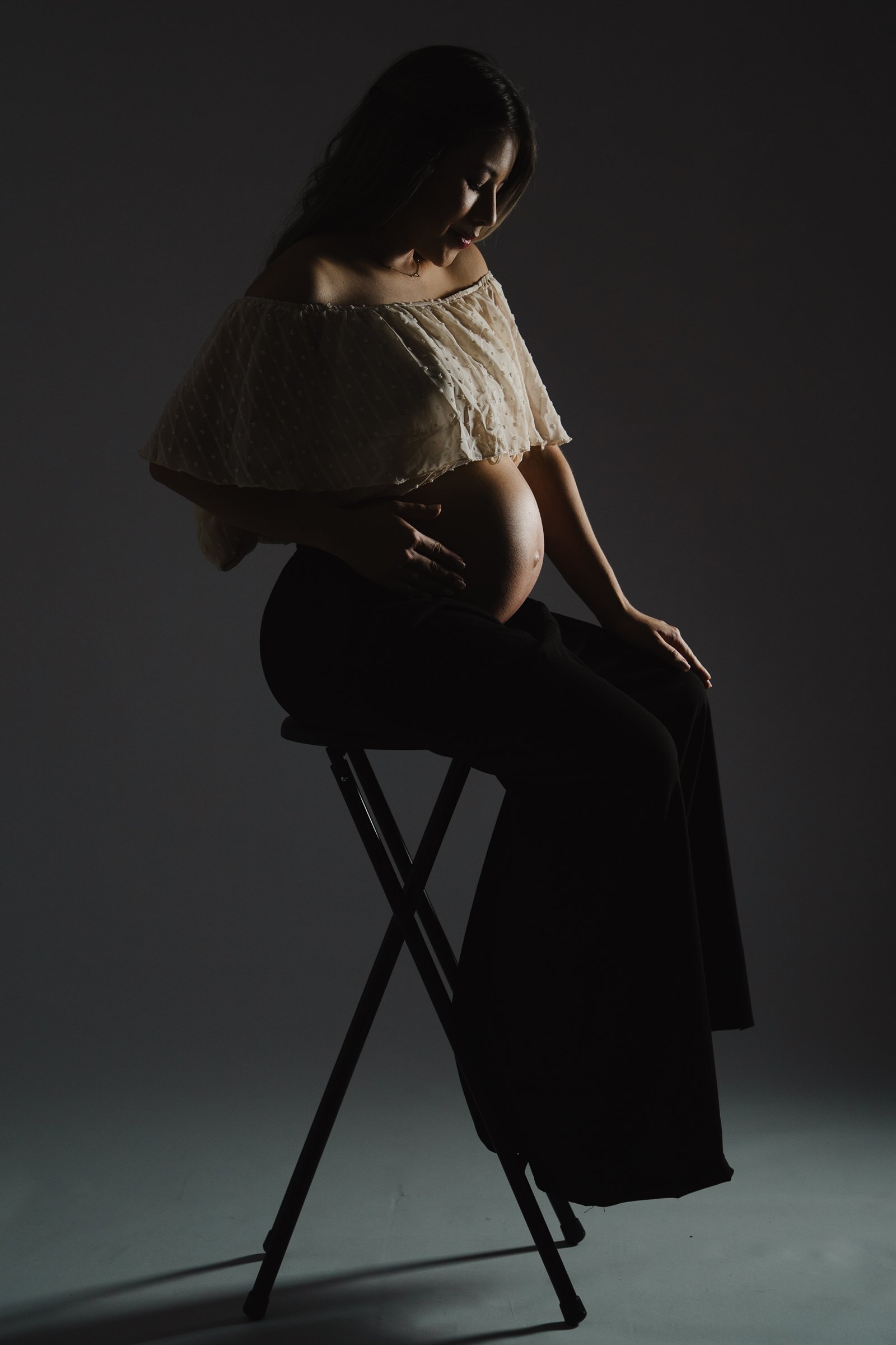 Retrato de maternidad de Fabi con iluminación dramática
